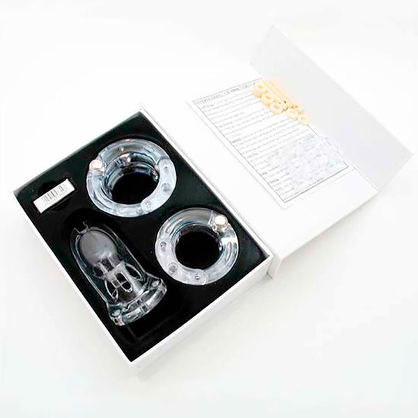 Clear HoD300 male chastity device kit inside the storage box, which has a foam insert holding the parts. It shows the cage and back rings next to the padlock box with the lid of the storage box open.