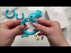 Assembling the blue kit using the supplied parts, which are all laid out on a marble table top. It's then locked together with a brass padlock.